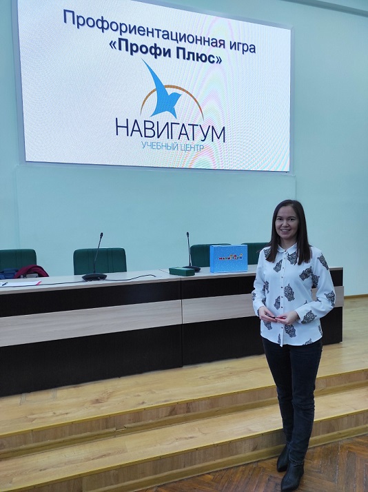 Айгуль Киреева в конференц-зале на фоне плаката "Профориентационная игра "Профи Плюс"